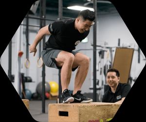 A man doing a box jump under the supervision of a Catalyst Physio therapist